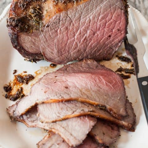 cooked and sliced bottom round roast beef sitting on platter