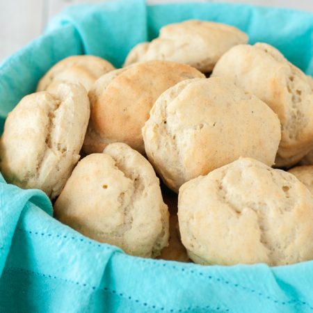 gluten free rolls sitting in basket lined with a blue napkin