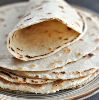 gluten free wraps sitting on plate with the top gluten free tortilla rolled