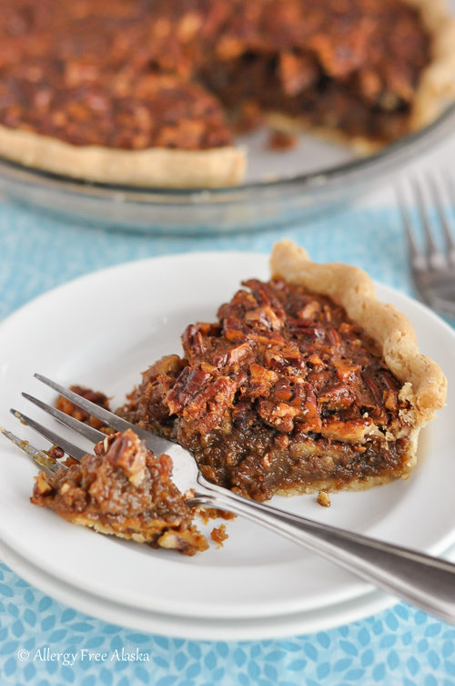 Gluten Free Corn Syrup Free Pecan Pie on plate with a pie cut off with fork, waiting to be eaten