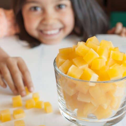 bowl of real fruit gummies with smiling child in background
