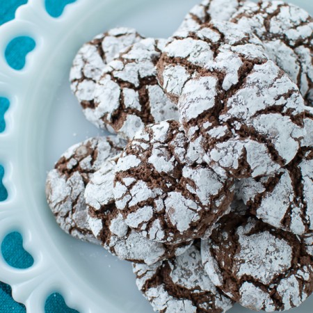 top down view of white platter piled high with gluten free chocolate crinkle cookies