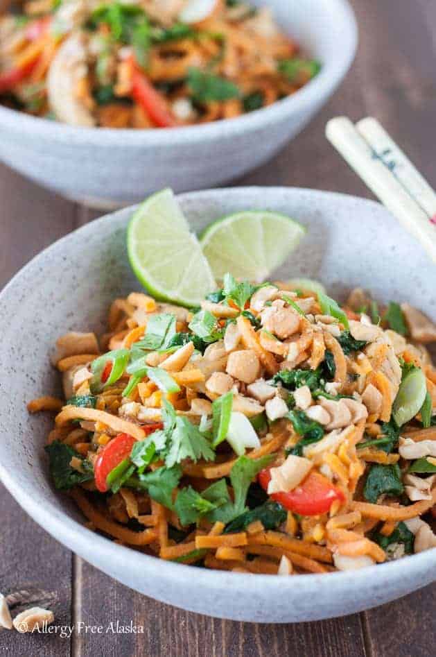 thai chicken sweet potato noodle bowl with lime wedges and chop sticks