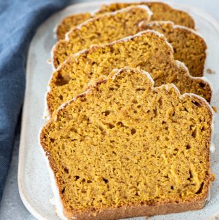 4 pieces of sliced gluten-free pumpkin bread sitting on white platter shot from different angle