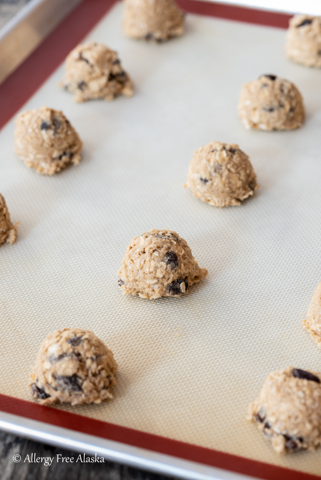 raw gluten free oatmeal cookie dough sitting in balls on baking sheet