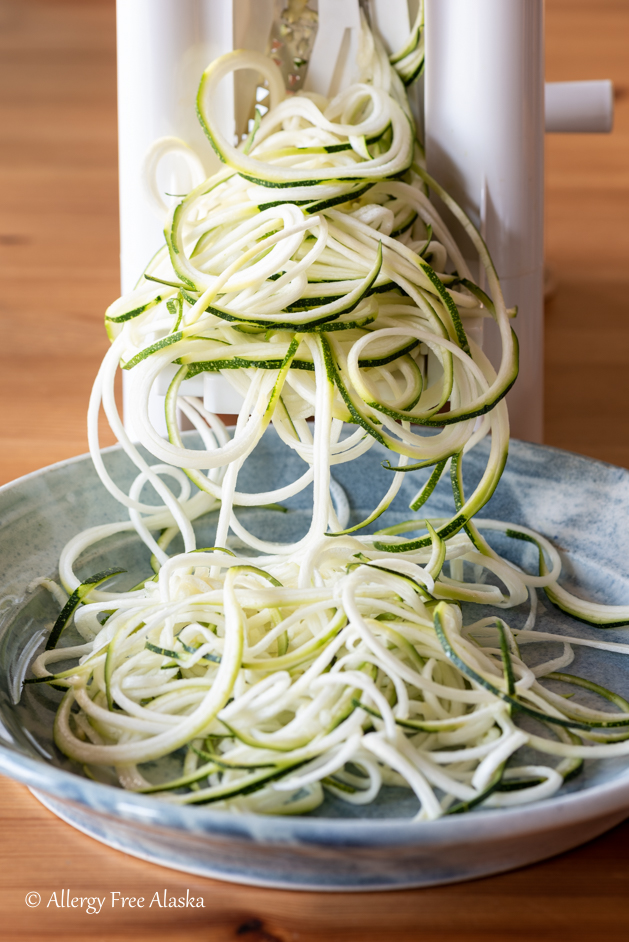 zucchini noodles coming out of spiralizer