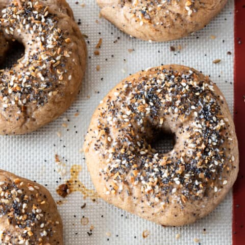 top down view of silpat lined baking sheet with baked gluten free everything bagels