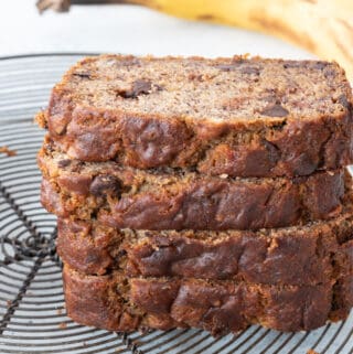 4 pieces of gluten-free banana bread stacked on top of one another on metal cooling rack