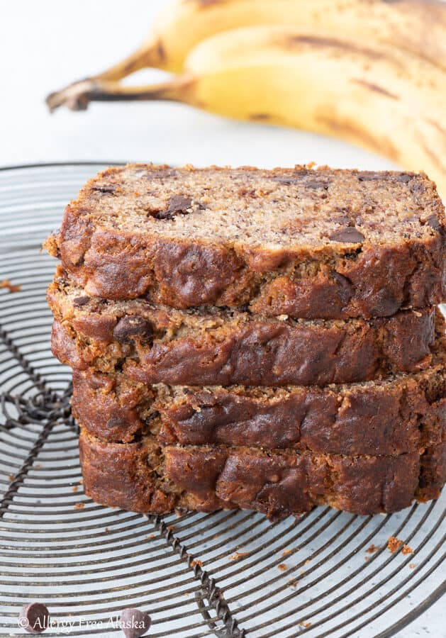 4 pieces of gluten-free banana bread stacked on top of one another on metal cooling rack