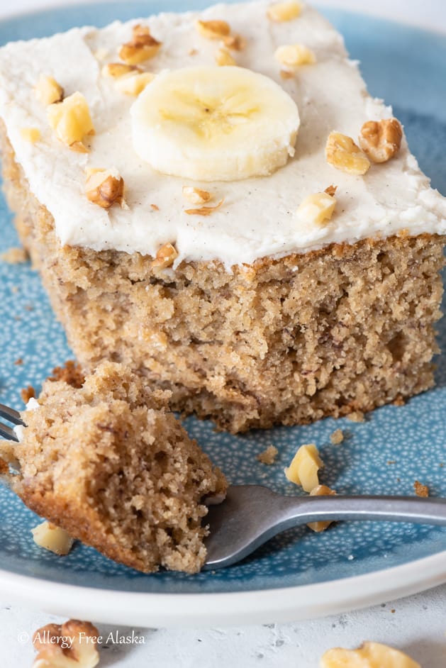 slice of gluten free dairy free banana cake with forkful of cake sitting on blue plate