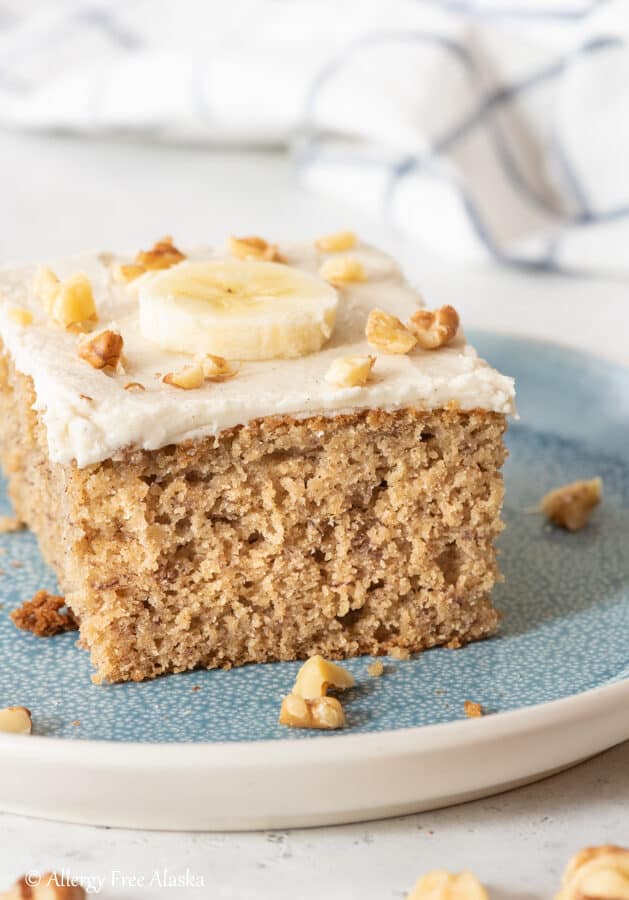 slice of gluten free cake topped with a banana slice and chopped walnuts