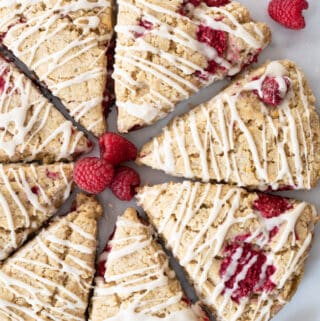 top down view of gluten free raspberry scones in circle formation with fresh raspberries sprinkled around them