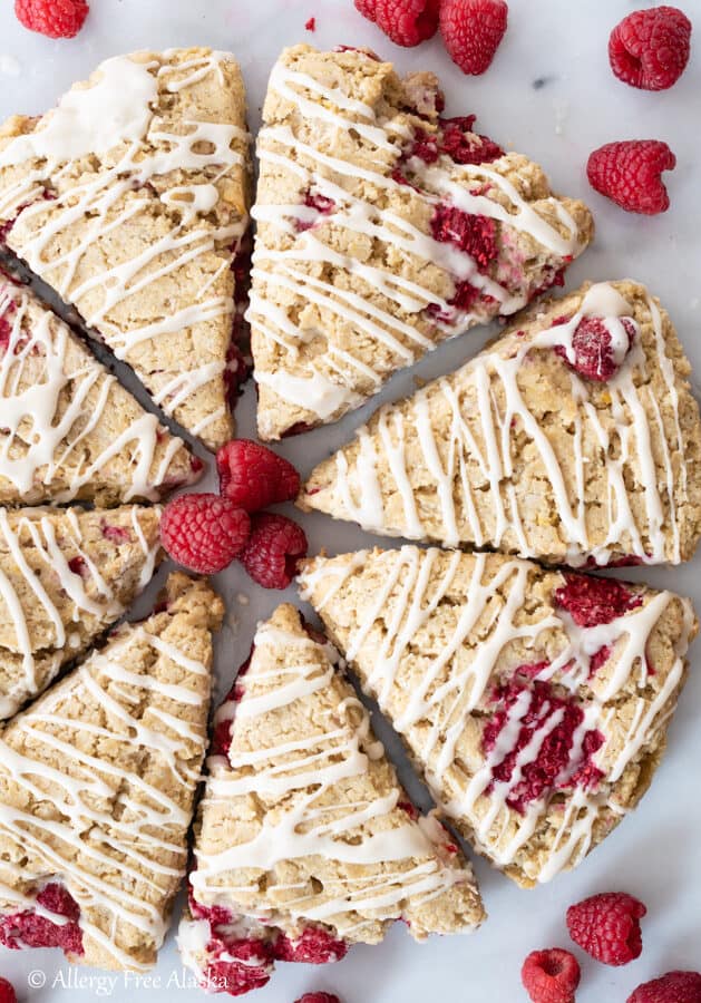 top down view of gluten free raspberry scones in circle formation with fresh raspberries sprinkled around them