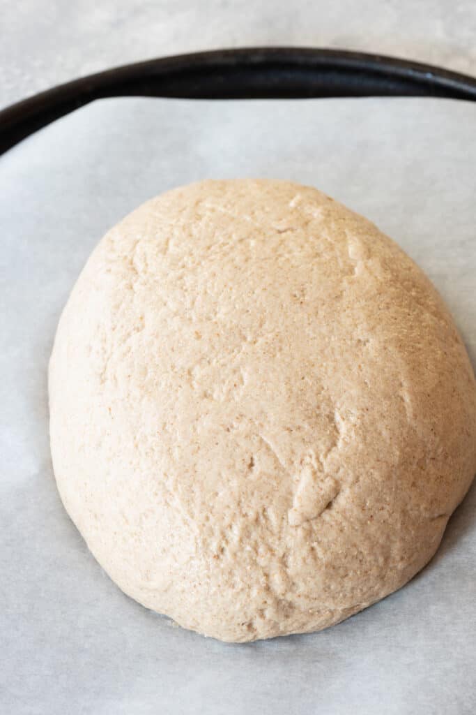 raw gluten-free bread dough in ball sitting on parchment paper
