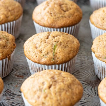 gluten free zucchini muffins in white paper liners sitting on metal tray