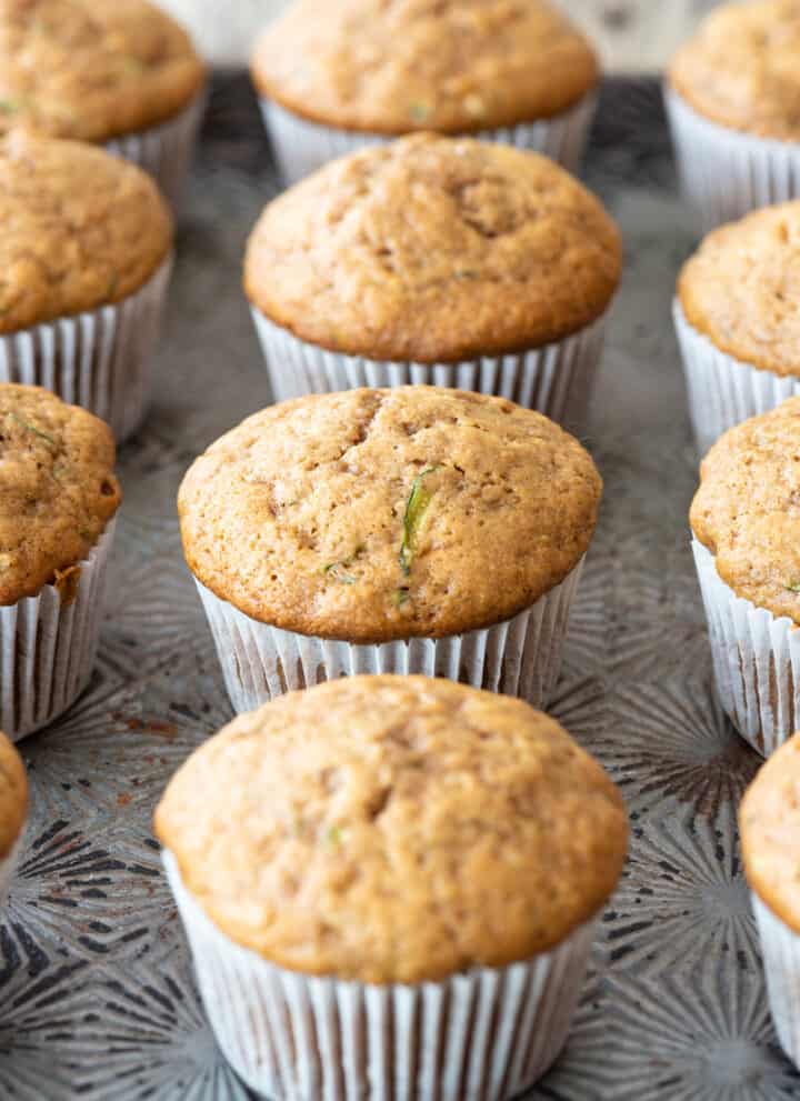 gluten free zucchini muffins in white paper liners sitting on metal tray
