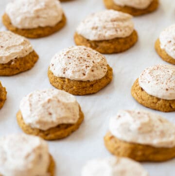 pumpkin gluten free cookies frosted with brown sugar icing on white background