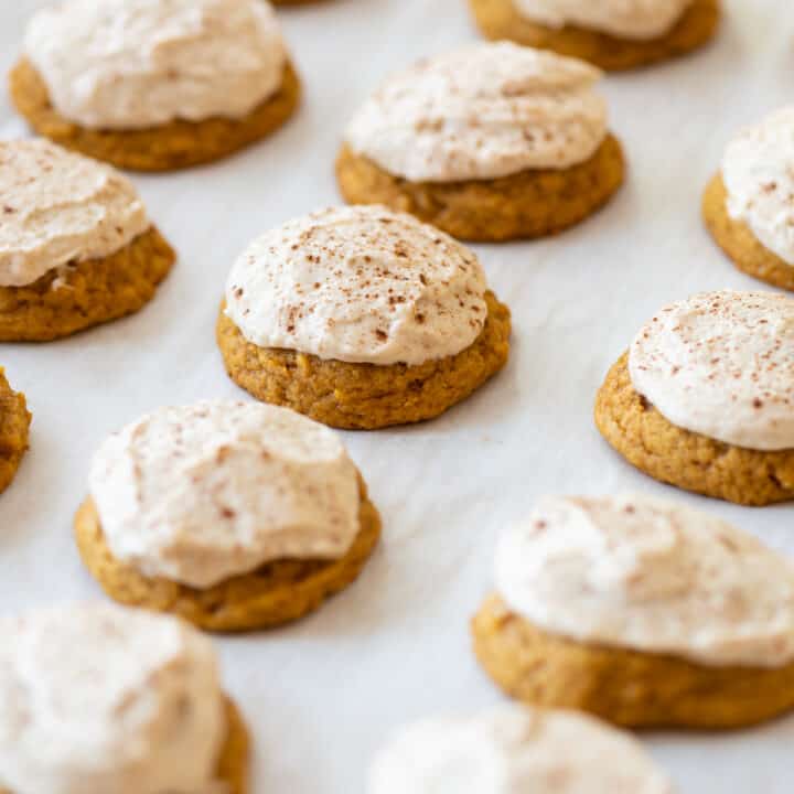 pumpkin gluten free cookies frosted with brown sugar icing on white background