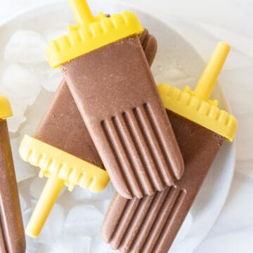 Close up: Top down view of 4 fudgesicles on white plate with ice cubes